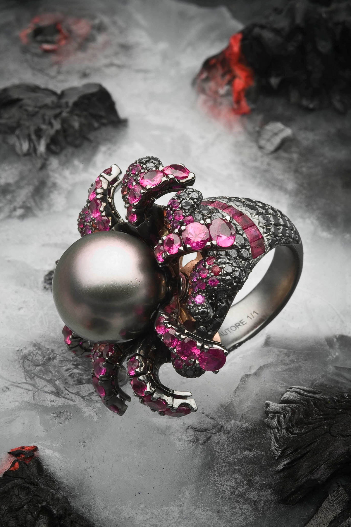 Fire & Ice ring with a dark South Sea pearl and pink gemstones amid lava and snow