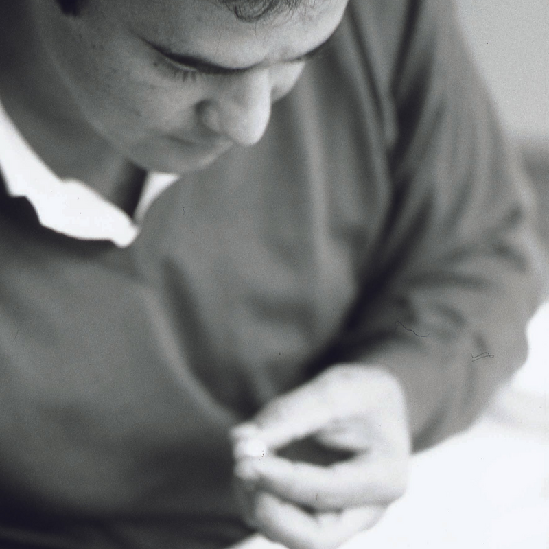 An AUTORE craftsman examining a single pearl