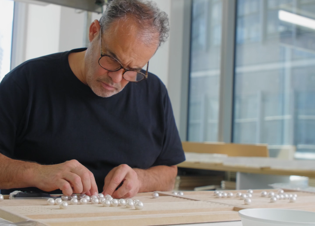 An AUTORE grader sorting South Sea pearls by hand beside a city window