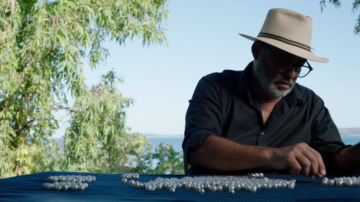 Rosario Autore hand-selecting South Sea pearls beside the water