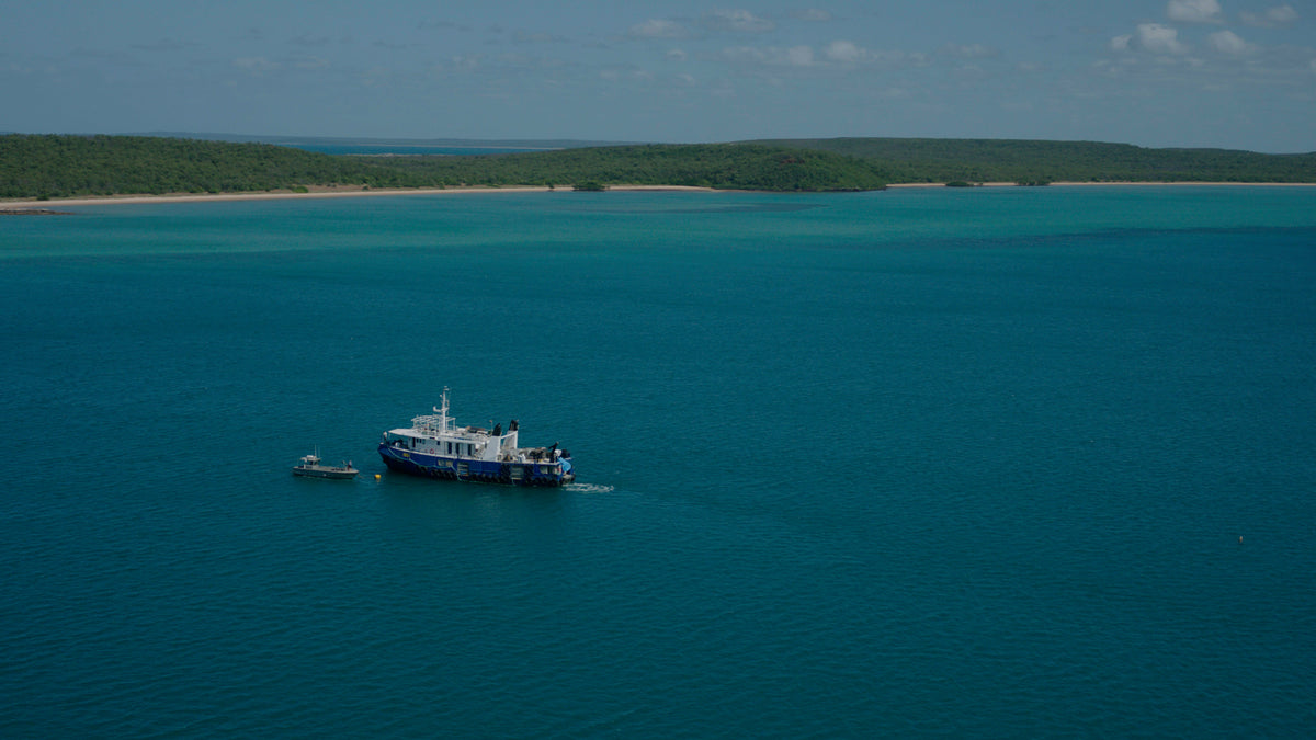 Aerial view of a pearling vessel in a turquoise bay off the Australian coastline